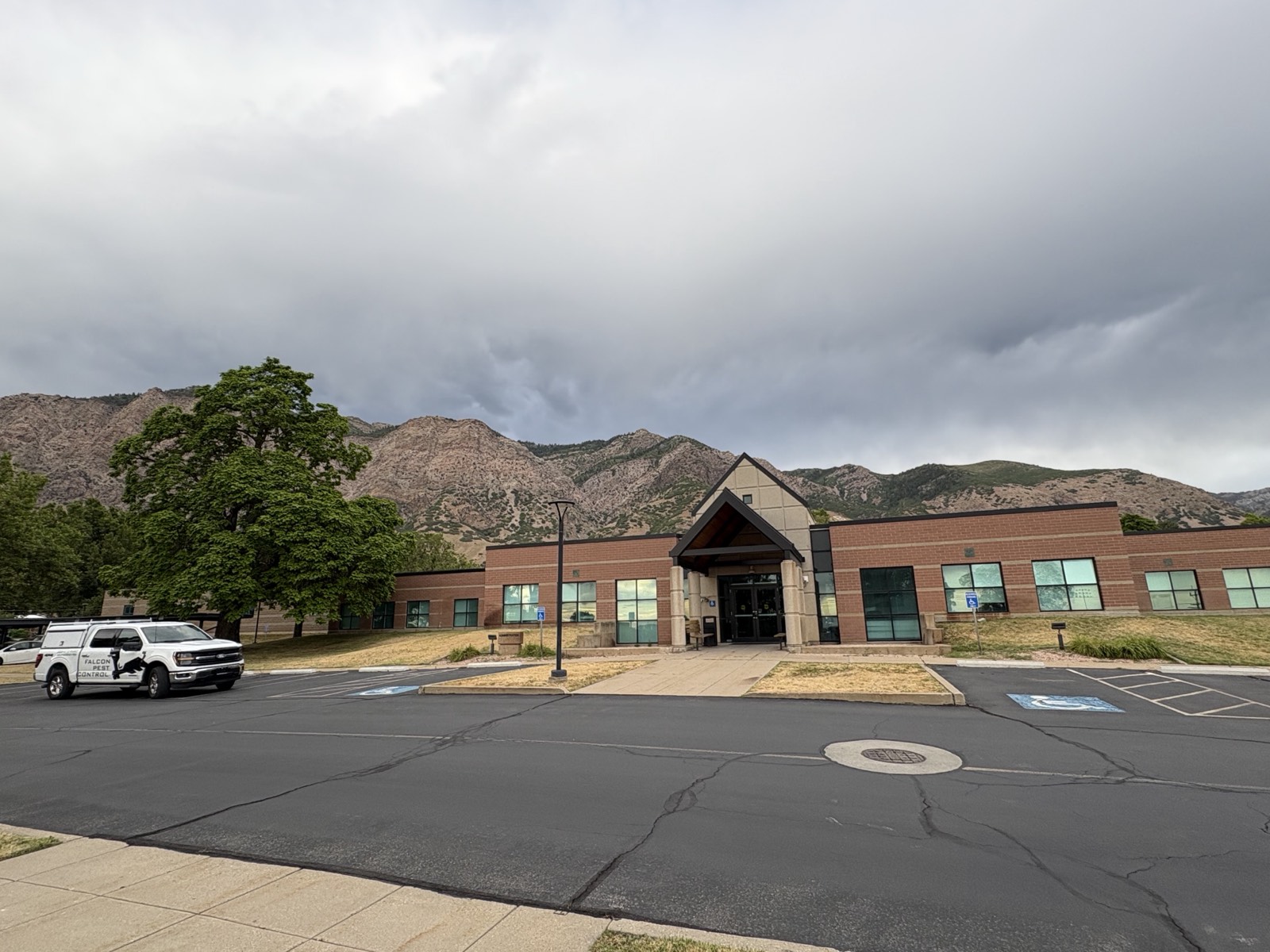 The USDB Ogden campus entrance, a brick building with a peaked entry against the mountains