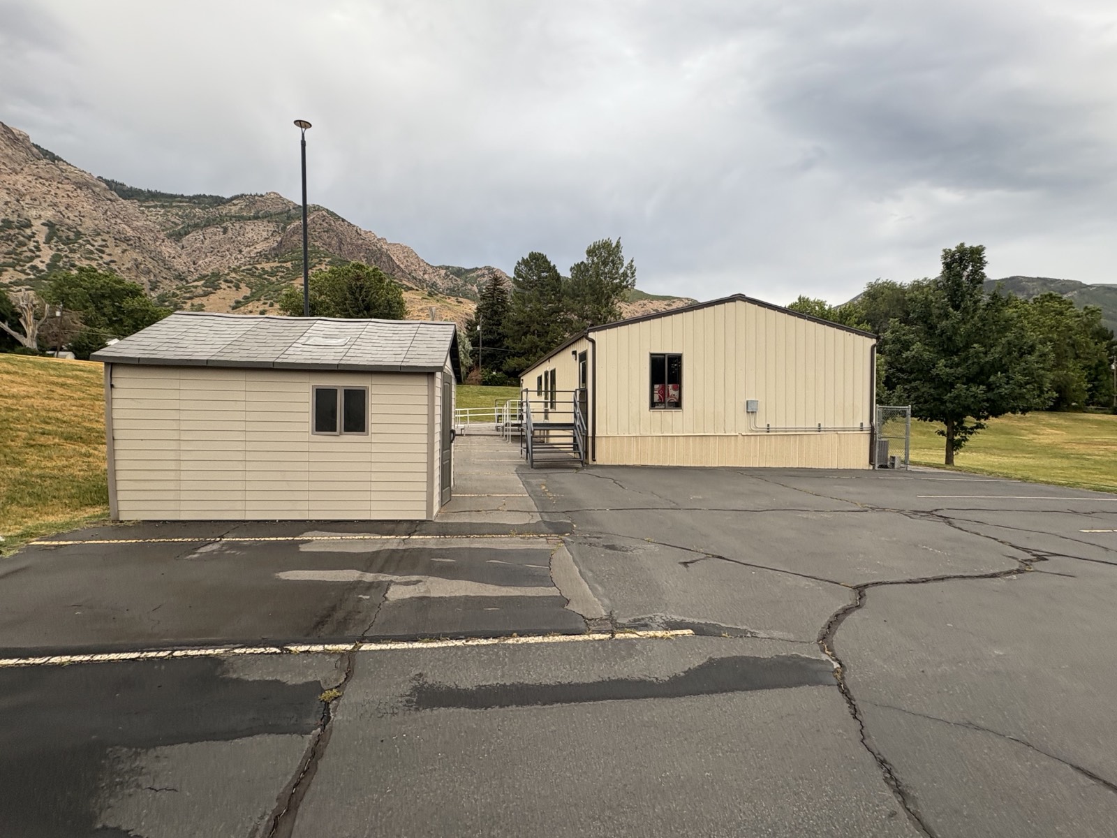 A portable building and outbuilding at the edge of the Ogden campus with open ground beyond