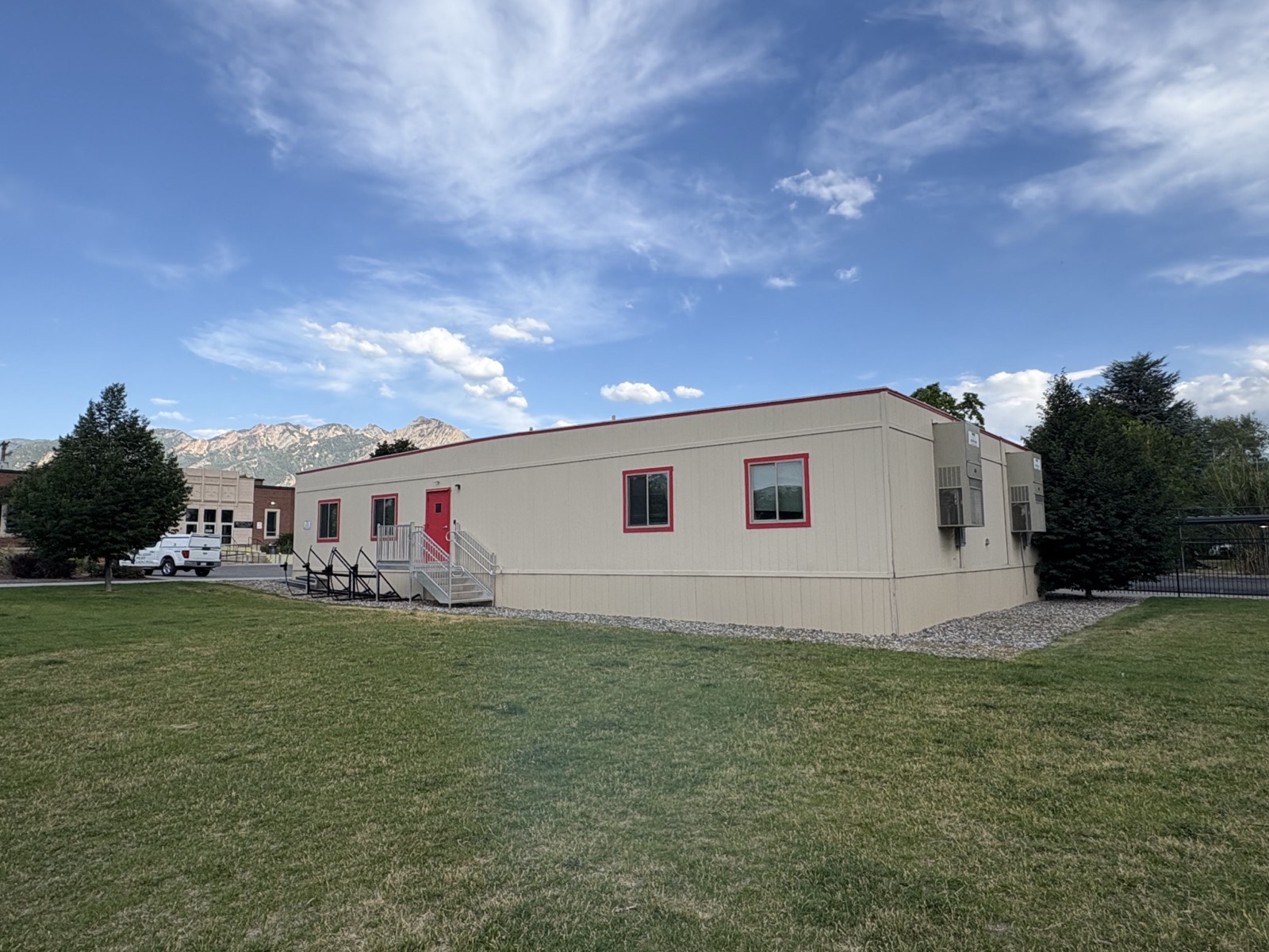 The portable building at the Salt Lake campus with lawn around it and mature trees at its corners