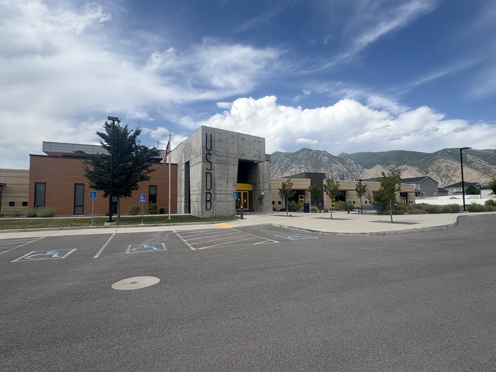 Elizabeth DeLong School entrance at the USDB Springville campus, with the USDB monument and mountains behind